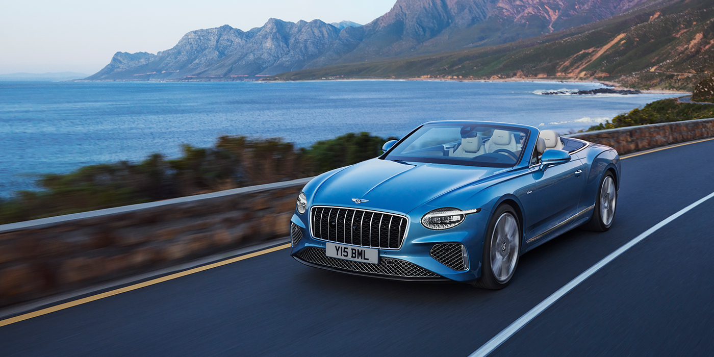 Bentley Tbilisi New Bentley Continental GTC Azure convertible in Light Windsor blue paint with 22 inch Azure wheels and chrome grill, driving dynamically by the sea