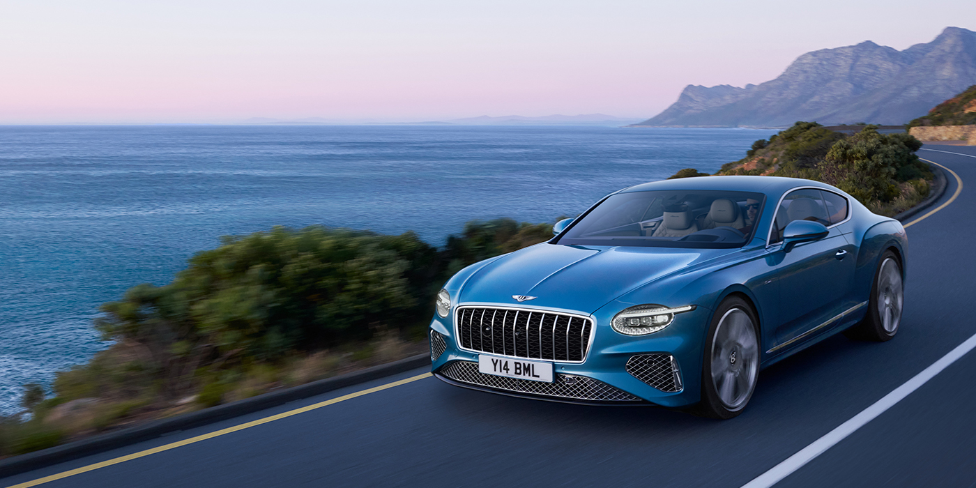 Bentley Tbilisi New Bentley Continental GT Azure coupe in Light Windsor blue paint with 22 inch Azure wheels and chrome grill, driving dynamically by the sea